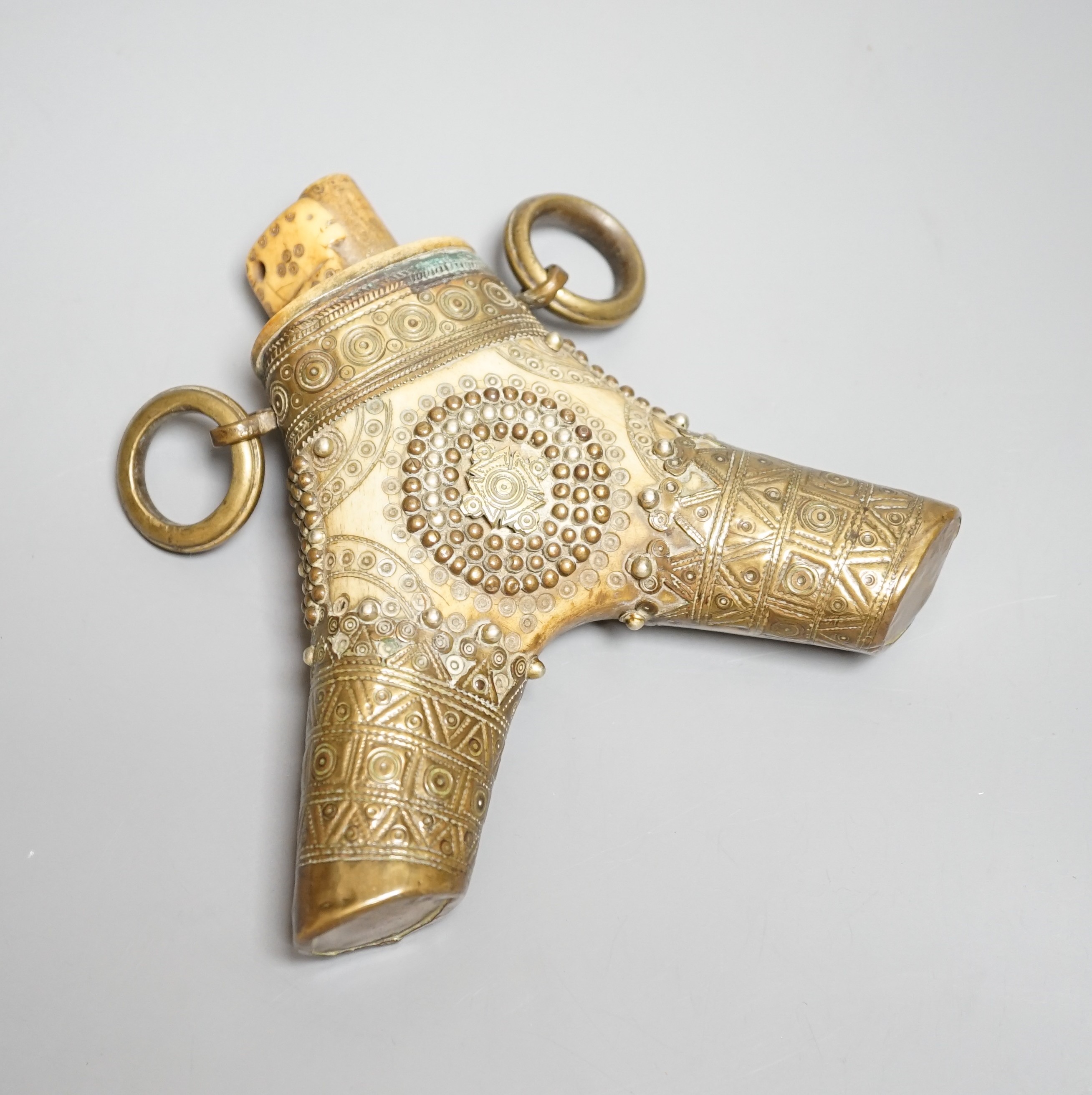 A Transylvanian staghorn powder flask 18th century, geometric decoration to body and brass mounts with central Teutonic order emblem. Maximum 16cms